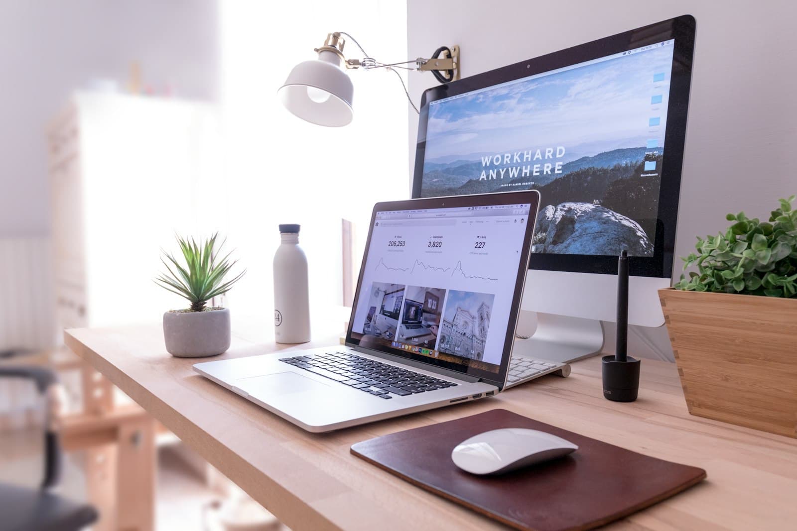 Poste de travail lumineux d'un créateur de sites : ordinateur portable et grand écran affichant une landing page